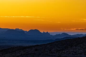 A golden sunset over Mule Ears Peaks, Big Bend.