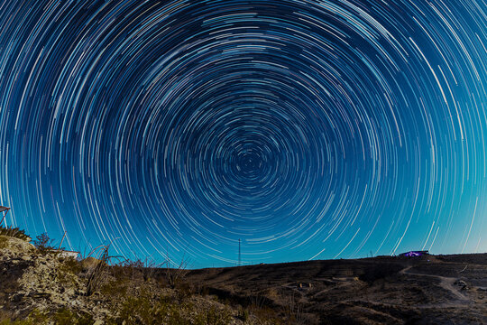 Circular star trails spin over the desert night in Terlingua.