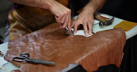 Skilled Artisan's Hands Meticulously Cutting Leather for Traditional Shoemaking and Crafting