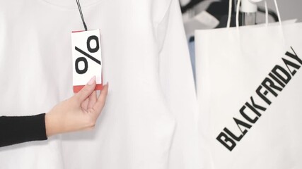 Woman shopping for Black Friday deals with stylish white sweatshirt