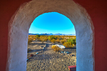 Fototapeta premium Temple Archway Framing Nevada Desert Path and Distant Mountains at Golden Hour