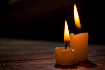 Close-up of burning candles arranged in a triangular composition. Warm glowing flames contrast with...