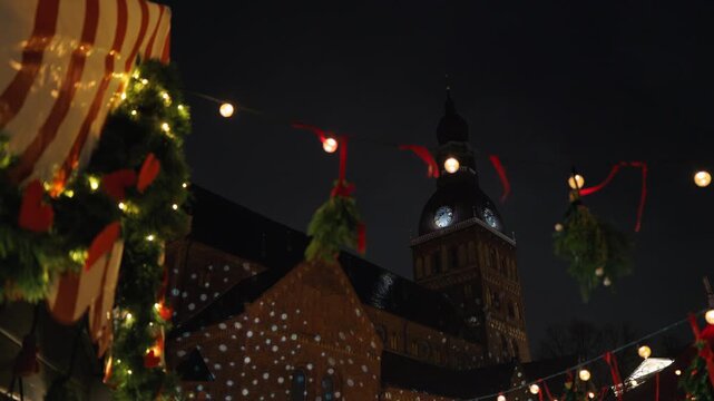 Seasonal greenery and mistletoe float across twilight sky with illuminated structures and lively market scenes slow motion