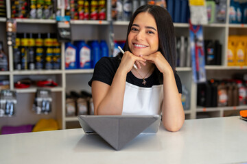 Young woman entrepreneur managing auto parts store displaying confidence and customer service