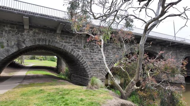 The historic bluestone bridge spanning the Barwon River in Winchelsea, Victoria, Australia. The arched stone structure is a regional heritage, Australian colonial infrastructure and rural town history