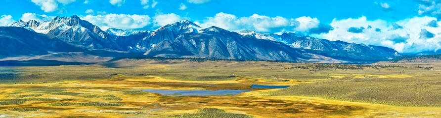 Fototapeta premium Aerial Panorama of Snow Capped Mountains and Golden Valley Eastern Sierra California