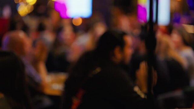 Faint image of gathering under illumination, Unclear group viewing energetic show in dim ambiance slow motion