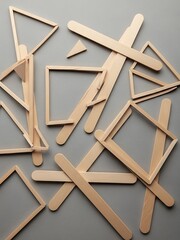 Scattered wooden sticks arranged in geometric shapes on a gray surface