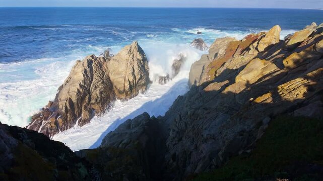 Pacific Ocean waves strike rugged coastal cliffs at Point Lobos State Natural Reserve in California