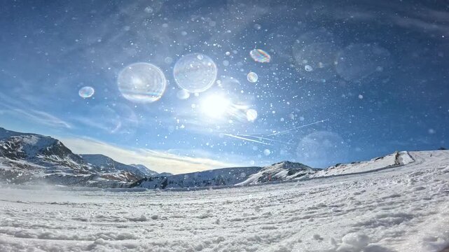 CLOSE UP, LENS FLARE, LOW ANGLE VIEW, SLOW MOTION: Smiling snowboarder drags his hand and sprays snow while carving on sunny ski slope. Winter fun and authentic snowboard action in Austrian Alps.