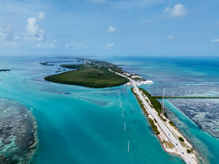 Aerial view of turquoise ocean, mangrove island and Overseas Highway in Florida Keys with boats and...