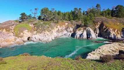 Waves surge against the rocky shoreline of the Pacific coast in California