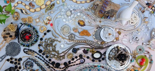 Second-hand jewelry arrangement in wave pattern on neutral background