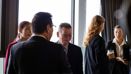Business professionals networking and engaging in casual conversation during corporate event in a modern office setting, illustrating connection, diversity, and leadership communication