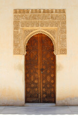 Fototapeta premium Wooden Door and Arabic Calligraphy Art Carved in Alhambra – Granada, Spain, July 2024