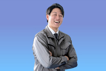 青背景と笑顔で腕を組む作業員
