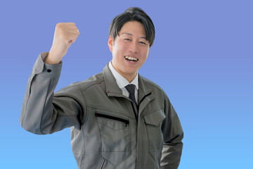 ガッツポーズする作業服男性