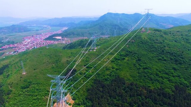High Voltage Power Tower Commissioning Over Mountain Valley Landscape