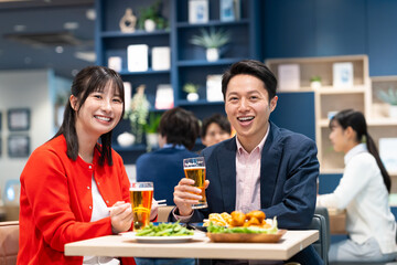 飲食店でビールを飲むミドルのカップル