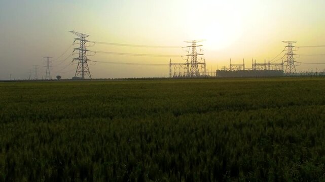 High Voltage Power Towers and Electrical Grid at Sunset