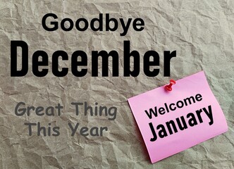 Goodbye December lettering on a grey paper background, welcome January on a pink sticker, new year...