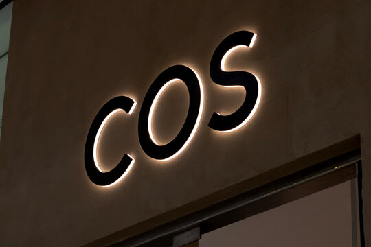 London, UK - December 18 2025: Illustrative editorial COS logo illuminated on minimalist fashion store signage above entrance
