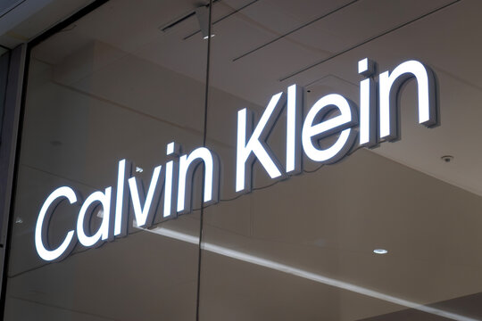 London, UK - December 18 2025: Illustrative editorial Calvin Klein logo illuminated on fashion retail store signage behind glass