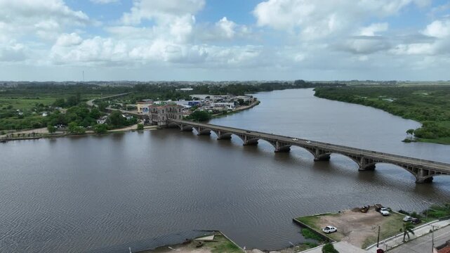 Cinematic forward camera movement flying parallel to the historic Maua International Bridge over Jaguarao River on the frontier between Brazil and Uruguay