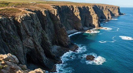 Rugged cliffs meet the ocean under a clear sky