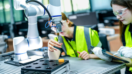 Two female engineers represent the future of work, using AI and robotics to optimize production....