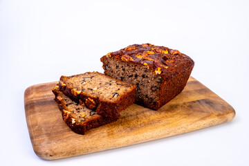 Delicious piece of banana and walnut cake on the wooden cutting board. Image close up view