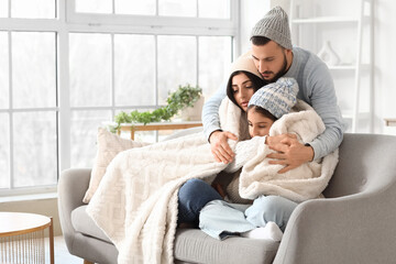 Frozen family in hats with plaid and lack of heating hugging at home