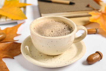 Cup of coffee with autumn leaves and acorn on white background © Pixel-Shot