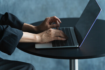 テーブルでラップトップを操作する女性　ライフスタイルイメージ