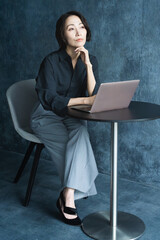 テーブルでラップトップを操作する女性　ライフスタイルイメージ