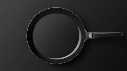 Black frying pan with handle isolated on dark background for food preparation