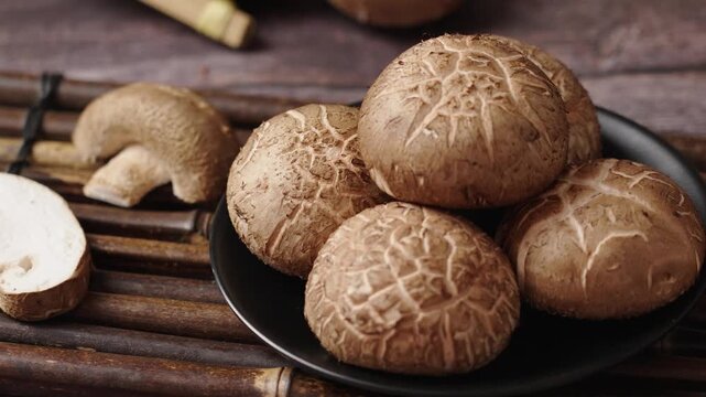 Shiitake mushrooms (Lentinus edodes) on wooden table.