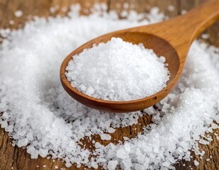 Close-up of coarse salt on a wooden spoon, surrounded by granules