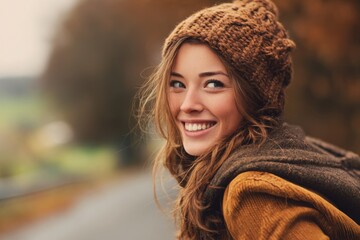 Smiling young woman in autumn outfit outdoors