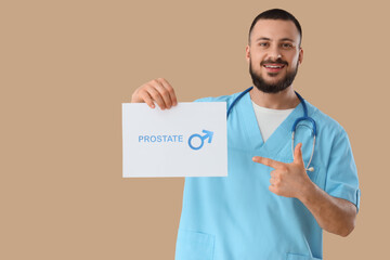 Male doctor pointing at paper with word PROSTATE on beige background. Cancer awareness concept