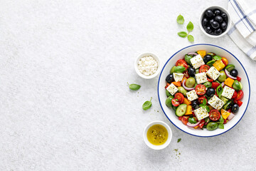 Greek Salad Culinary Delight: An appetizing overhead shot showcases a vibrant Greek salad in a white bowl, its medley of fresh vegetables, olives, and feta cheese a feast for the eyes.