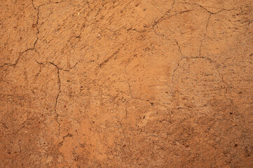 Full frame shot of an earthen wall texture of clay house structure. These walls are constructed by ramming a mixture of aggregates, including gravel, sand, silt and a small amount of clay.