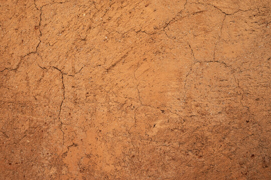 Full frame shot of an earthen wall texture of clay house structure. These walls are constructed by ramming a mixture of aggregates, including gravel, sand, silt and a small amount of clay.