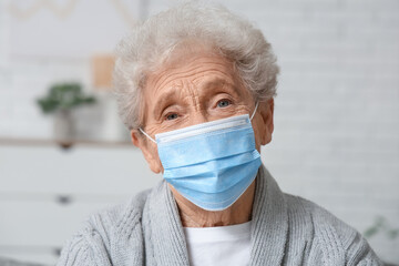 Elderly woman in medical mask at home