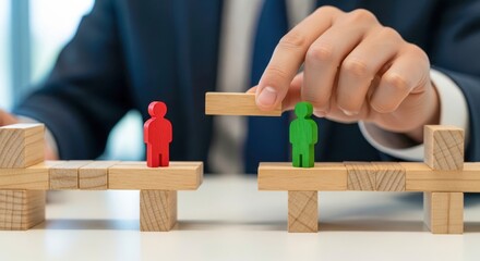 Hand builds wooden bridge between two figurines. Mediator solving conflict. Bridge represents understanding and connection. Figures symbolize people groups. Mediation and conflict resolution concept.
