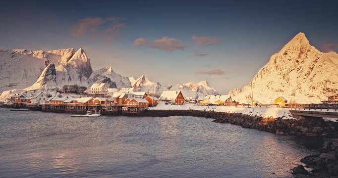 Lofoten islands beautiful nature sunset landscape in Norway and fishing town with scenic yellow rorbu houses of Sakrisoy, Reine