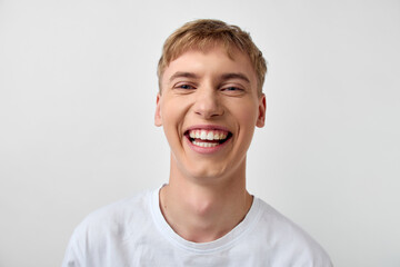 Smiling man in a white t shirt with bright joyful expression, close up headshot style, positive mood, friendly vibe for lifestyle or wellness themes