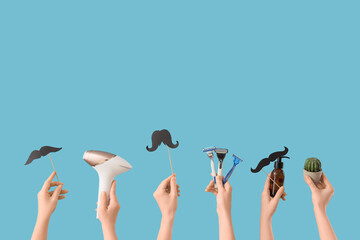 Many female hands with photoepilator, razors and paper mustache on blue background. Depilation...