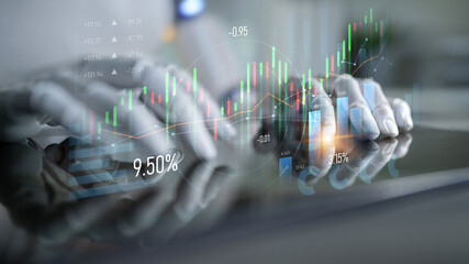 A close-up view of hands working on a reflective surface with digital stock market charts and data...