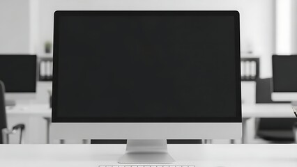 Contemporary all-in-one desktop workstation with a dark blank display in a minimalist office environment